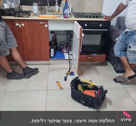 תיק כלים פתוח עם כלי עבודה ליד ארון מטבח פתוח